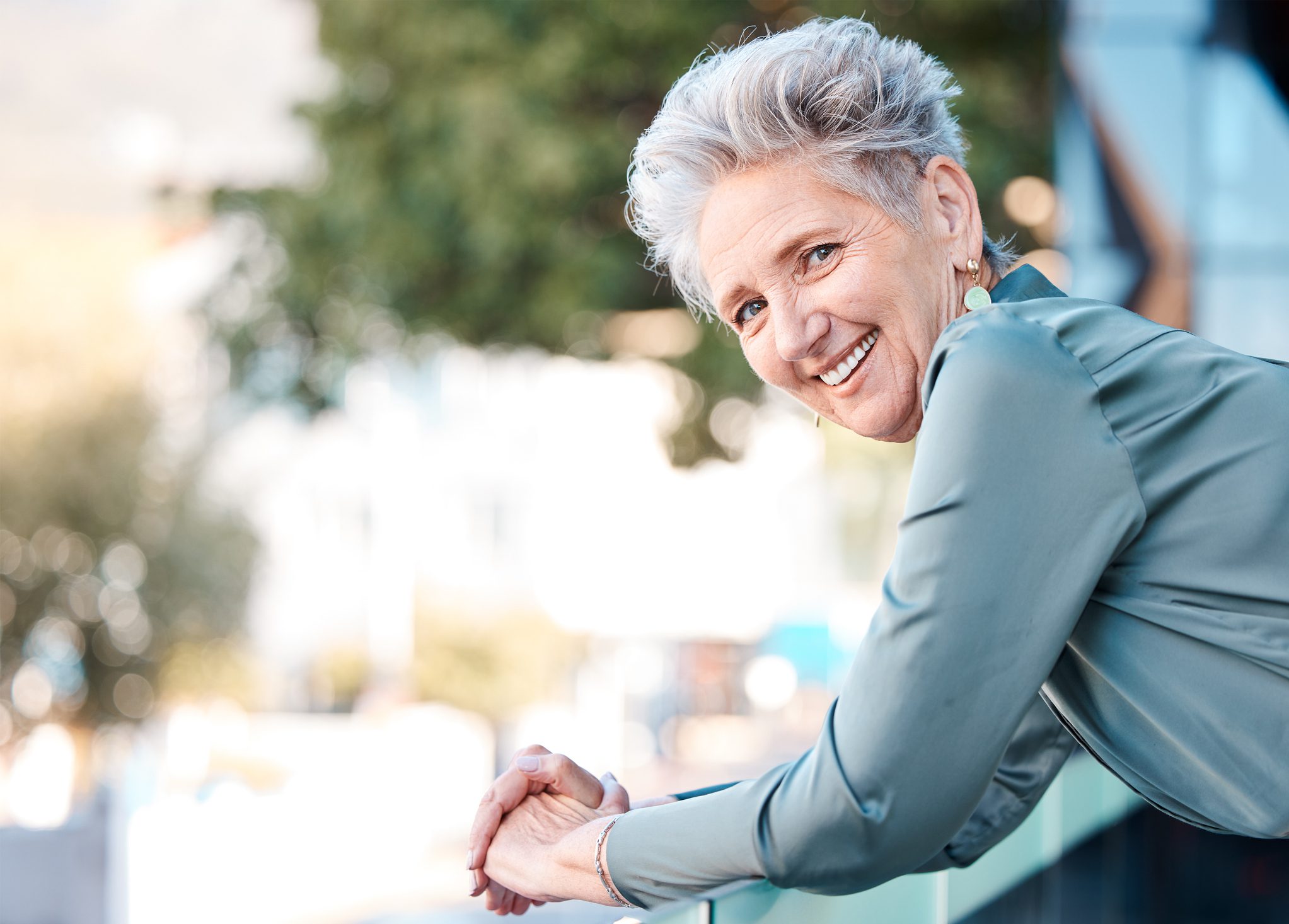 Portrait, city and mockup with a woman manager in business standing outdoor on the balcony of her office. Face, happy and smile with a senior female CEO or boss outside during summer in an urban town