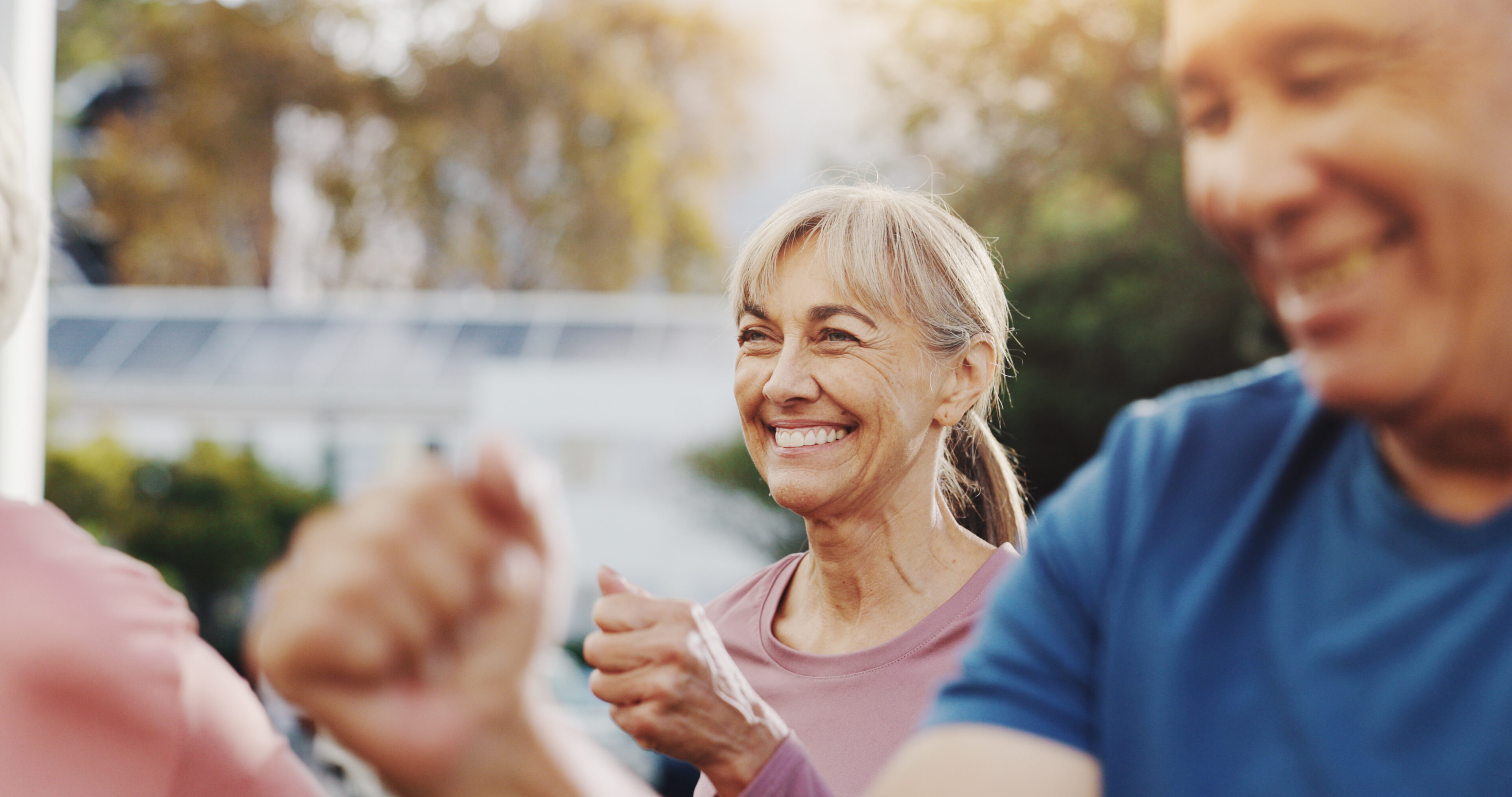 Senior woman, exercise and group in garden at retirement village, health and fitness class in morning. Elderly people, workout and diversity with cardio training, excited and wellness in summer